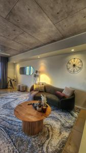 - un salon avec un canapé et une table dans l'établissement Penthouse-level Waterfront Apartment, à Darwin