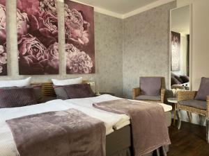 Rein Klassik Hotel في باد بيرمونت: غرفة نوم بسريرين و كرسيين