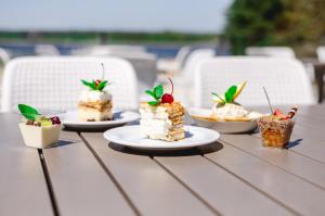 einen Tisch mit Kuchen und Desserts auf Platten in der Unterkunft Centrum Konferencyjno Rekreacyjne Molo in Smardzewice