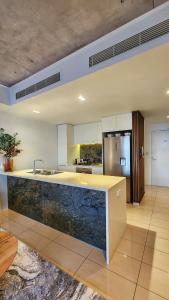 a large kitchen with a counter and a sink at Penthouse-level Waterfront Apartment in Darwin