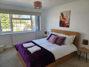 a bedroom with a large bed with two towels on it at Kennedy Villa - 5 Bedroom House with Hot Tub, WiFi, Free parkings, Close to Bicester Village in Bicester +38 photos