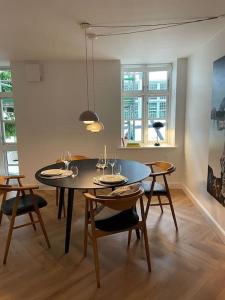 comedor con mesa y algunas sillas en Nyrenoveret charmerende lejlighed i Odense C!, en Odense