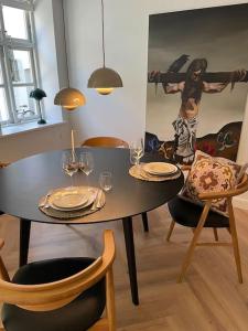 a dining room with a table and chairs with wine glasses at Nyrenoveret charmerende lejlighed i Odense C! in Odense