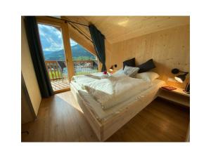 a bedroom with a bed and a desk with a window at Alpenchalét Alpakablick in Sankt Lorenzen ob Murau