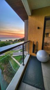 a balcony with a view of the ocean at sunset at Penthouse-level Waterfront Apartment in Darwin