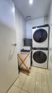a washer and dryer in a small room at Penthouse-level Waterfront Apartment in Darwin