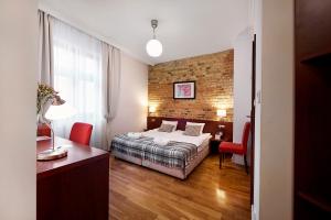 1 dormitorio con 1 cama y escritorio en una habitación en Gołębia 8 Residence, en Cracovia