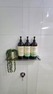 three bottles of wine sitting on a shelf in a bathroom at Penthouse-level Waterfront Apartment in Darwin