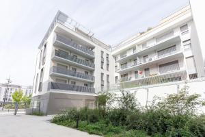 un edificio de apartamentos con balcones en un lateral en L'élégant T2 proche de Versailles et de Paris en Guyancourt