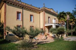 una vecchia casa con una palma di fronte di Château de Larunque, 15 p, piscine spa tennis - plages 30 mn a Saint-Laurent-de-Gosse