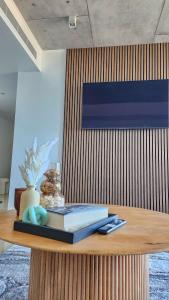 a wooden table with a book and a vase on it at Penthouse-level Waterfront Apartment in Darwin