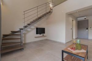 ein Wohnzimmer mit einer Treppe und einem TV in der Unterkunft Mystique Luxury Suites & Maisonettes in Laganas