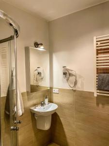 a bathroom with a sink and a shower at Glam House Apartments in Poznań