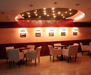 a dining room with tables and chairs and lights at Hotel Praha in Uzhhorod