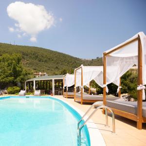 una piscina in un resort con una montagna sullo sfondo di Skiathos Avaton Garden, Philian Hotels and Resorts a Città di Skiathos