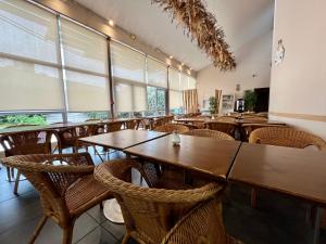 uma sala de jantar com mesas e cadeiras de madeira em Résidence Otellia em Blanquefort