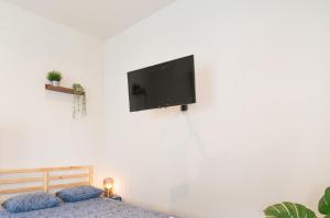 um quarto com uma cama e uma televisão de ecrã plano na parede em Antwerp Center Cozy Cityflats em Antuérpia