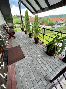 une terrasse avec des plantes en pot et une clôture dans l'établissement Pensiunea Longocampo, à Cîmpulung