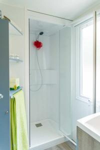 a bathroom with a shower with a glass door at Camping La Croix du Sud in Le Barcarès