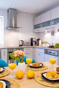 a kitchen with a table with glasses of orange juice at Design Apartment-bis 4 Pers-Vollwertige Küche-Parkplatz-WiFi-Garten-Terrasse in Schiffweiler