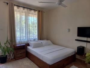 A bed or beds in a room at Adhiambo's Studio near Bofa Beach