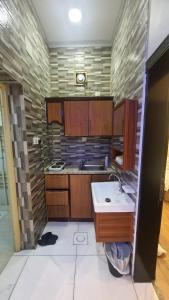 a kitchen with wooden cabinets and a sink at شاليهات قمرا in Qarār