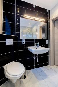 a bathroom with a white toilet and a sink at Stilvolles Design-Apartment in Schiffweiler - bis 4 Pers - ruhig gelegen - Balkon mit Gartenzugang - private Terrasse - WLAN - 2 Parkplätze - Self-Check-in - Nähe See & Wald in Schiffweiler