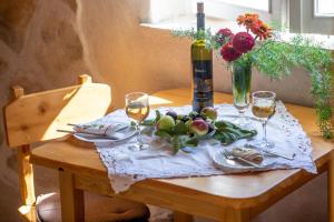 a table with glasses of wine and a vase of flowers at Stone House Harmony in Korčula