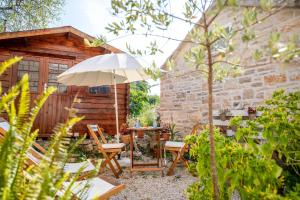 a patio with a table and an umbrella at Stone House Harmony in Korčula