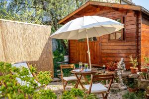 a table with an umbrella in front of a cabin at Stone House Harmony in Korčula