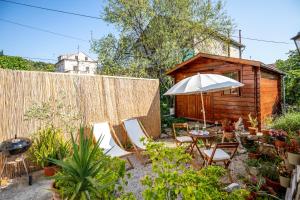 a garden with chairs and an umbrella and a wooden shed at Stone House Harmony in Korčula