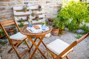 a table and chairs in a garden with plants at Stone House Harmony in Korčula