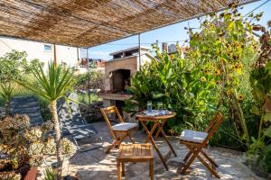 a patio with a table and chairs and a pizza oven at Stone House Harmony in Korčula