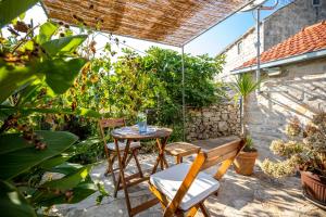 a patio with a table and chairs and plants at Stone House Harmony in Korčula