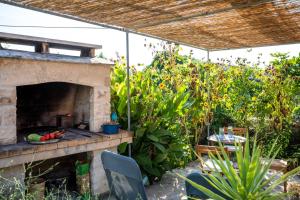 a patio with a stone fireplace in a garden at Stone House Harmony in Korčula