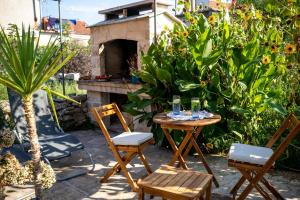 a patio with a table and chairs and a fireplace at Stone House Harmony in Korčula