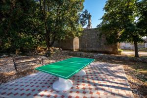 a green ping pong table in a park with a bench at Stone House Harmony in Korčula