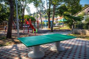 a ping pong table in a park with a playground at Stone House Harmony in Korčula