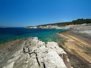 a beach with rocks and the water and a boat at Stone House Harmony in Korčula