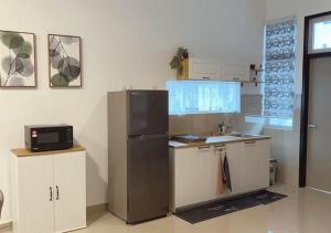 a kitchen with a stainless steel refrigerator and cabinets at MaisonStay, Iconia Residance, Johor Bahru in Johor Bahru