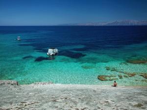 a person sitting on the shore of a body of water at Stone House Harmony in Korčula