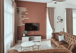 ein Wohnzimmer mit einem Sofa und einem TV in der Unterkunft MaisonStay, Iconia Residance, Johor Bahru in Johor Bahru