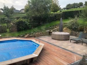 una piscina su una terrazza in legno con vasca idromassaggio di « En toute simplicité chez Fabienne et Bruno » a Waimes