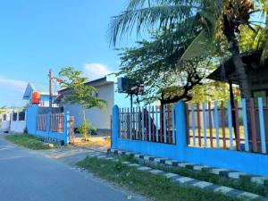 una recinzione blu sul lato di una strada di RedDoorz @ Wisma Sentosa Palopo a Palopo