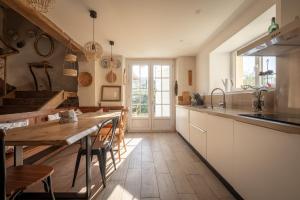 uma cozinha com uma mesa de madeira e uma sala de jantar em Ferme Sarthou em Lucq-de-Béarn