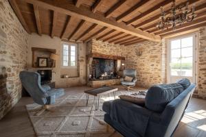 a living room with two chairs and a fireplace at Ferme Sarthou in Lucq-de-Béarn