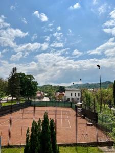 a tennis court with a tennis court at Pensiunea Longocampo in Cîmpulung