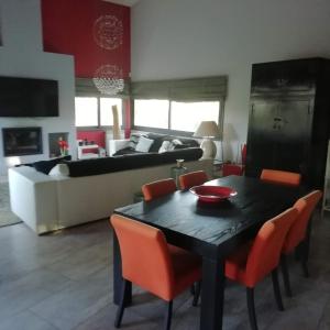 El Arrabal de Coll dʼArbós的住宿－CASA NEUS，客厅配有黑色桌子和橙色椅子