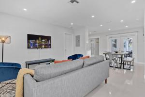 Modern Fort Lauderdale Pool Home في فورت لاودردال: غرفة معيشة مع أريكة وغرفة طعام