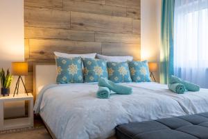 a bedroom with a large bed with blue pillows at Design Apartment-bis 4 Pers-Vollwertige Küche-Parkplatz-WiFi-Garten-Terrasse in Schiffweiler